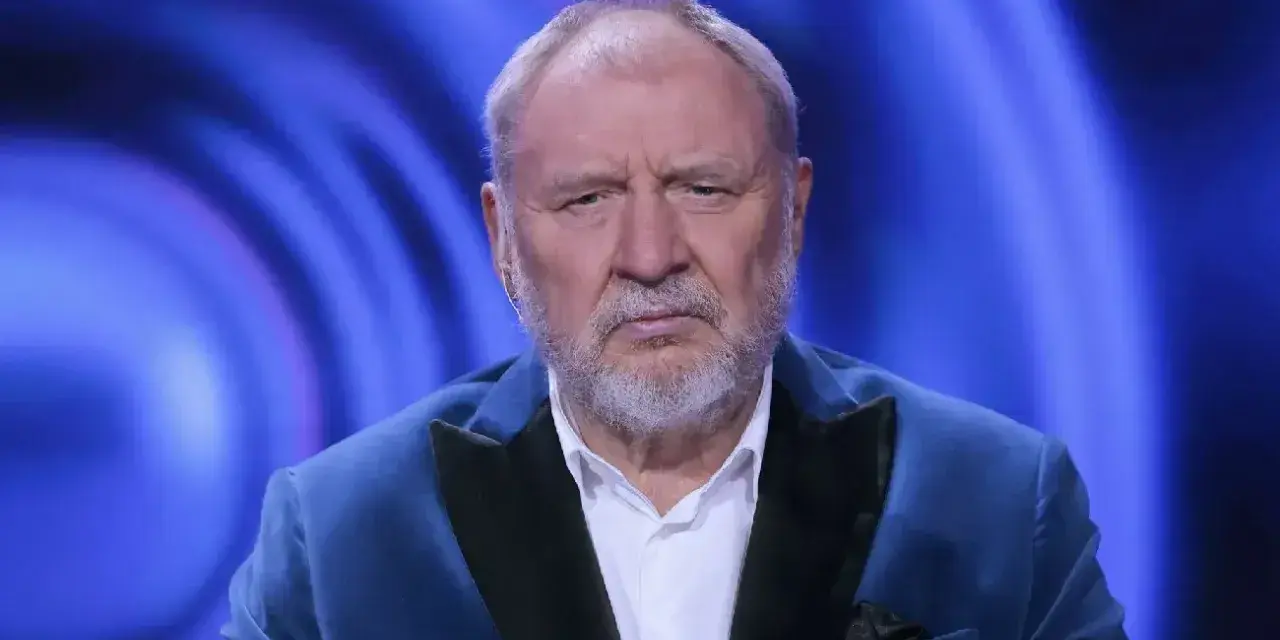 Andrzej Grabowski żyje i wygląda na zmęczonego, siedząc w niebieskiej marynarce na tle niebieskich świateł.