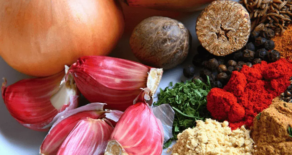Cebollas, ajos rosados y especias como pimentón y comino, algunos de los alimentos ricos en quercetina para una dieta saludable.