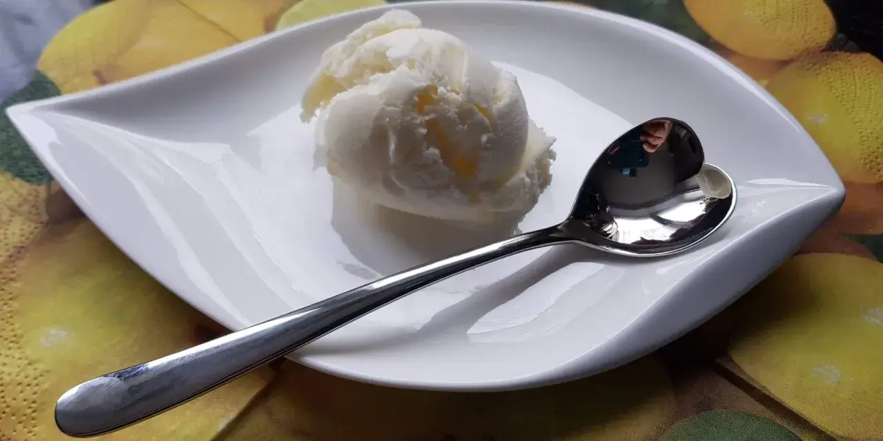 Cremiges Batida de Coco Eis auf einem Blatt-Teller, bereit zum Genießen.