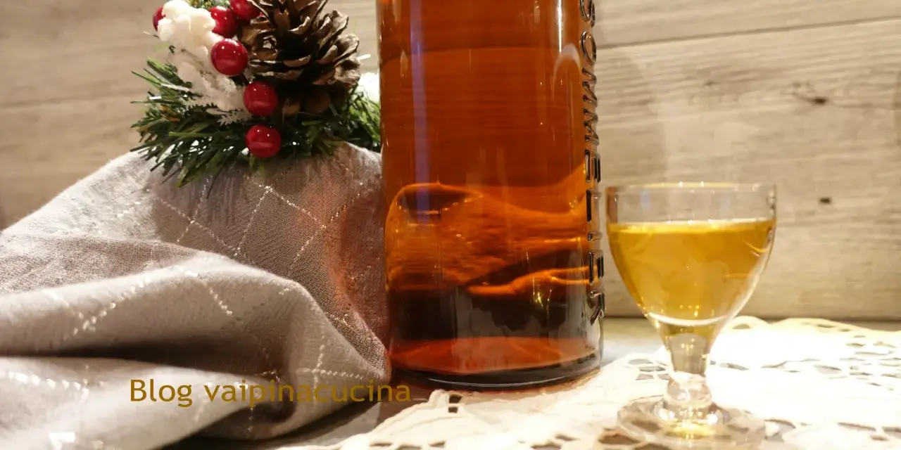Liquore genziana ricetta: bottiglia ambrata, bicchierino dorato e decorazione natalizia.