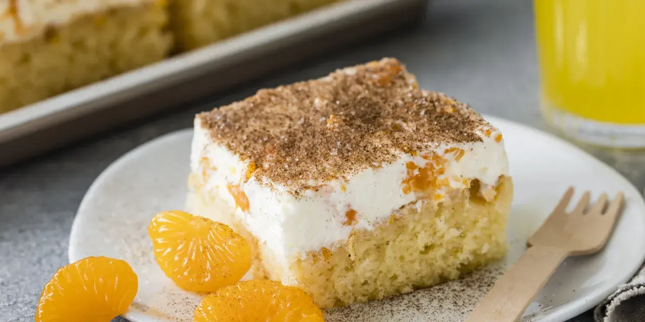 Ein Stück saftiger Fantakuchen mit cremiger Füllung und Mandarinenstücken, bestreut mit Zimt. Perfekt für das Fantakuchen Rezept!