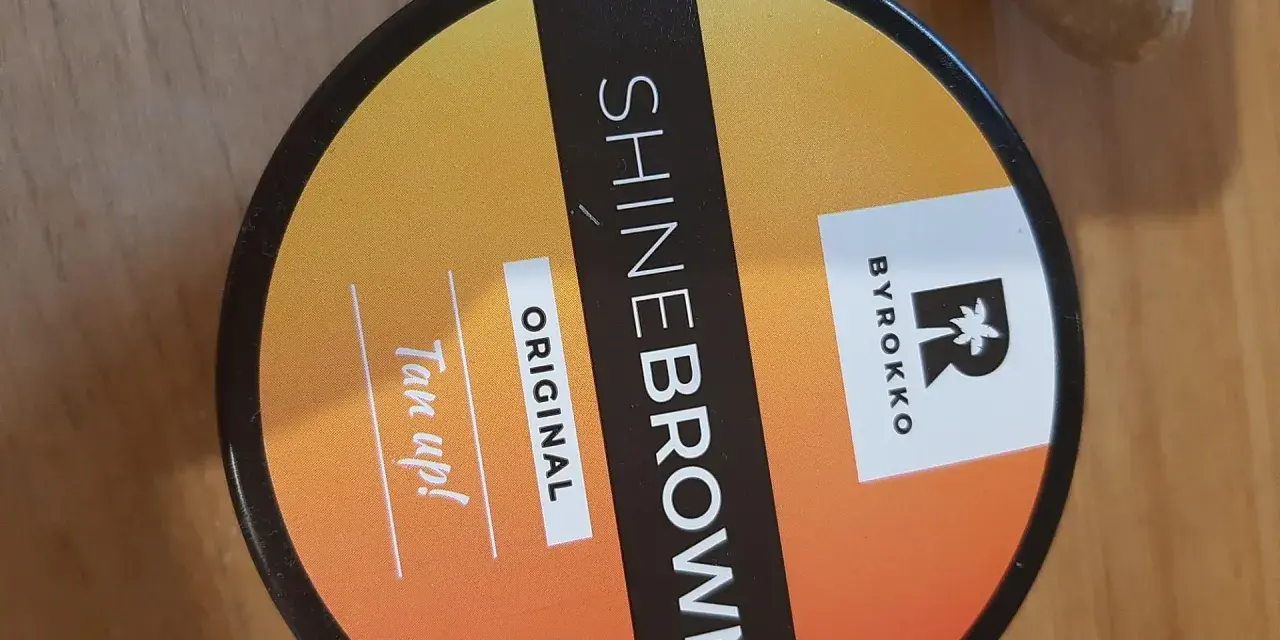 Puszka z produktem BYROKKO Shine Brown Original. "Tan up!" - zachęta do opalania.