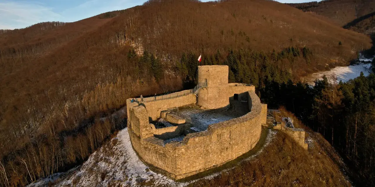 Ruiny zamku na wzgórzu, otoczone lasem. To wspaniałe rytro atrakcje, idealne na zimowy spacer.