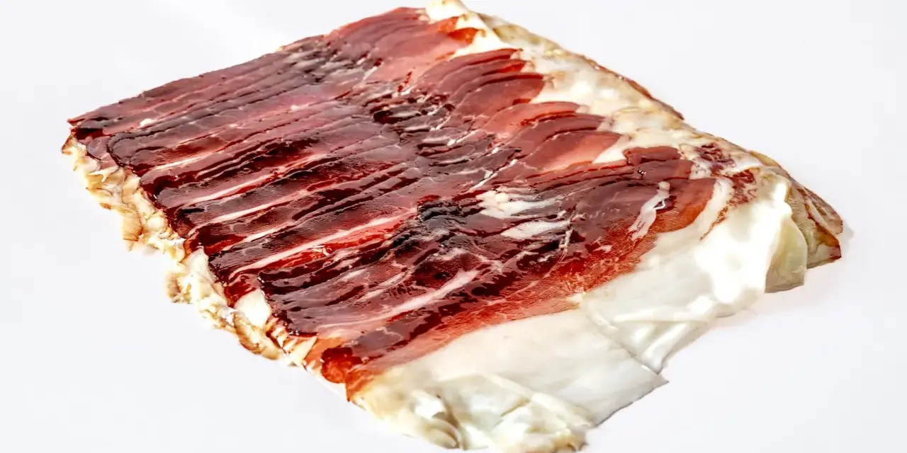 Dünn geschnittener, aromatischer Schinken vom Angler Sattelschwein. Das Fleisch ist dunkelrot mit feinen Fettäderchen und einem weißen Fettrand.