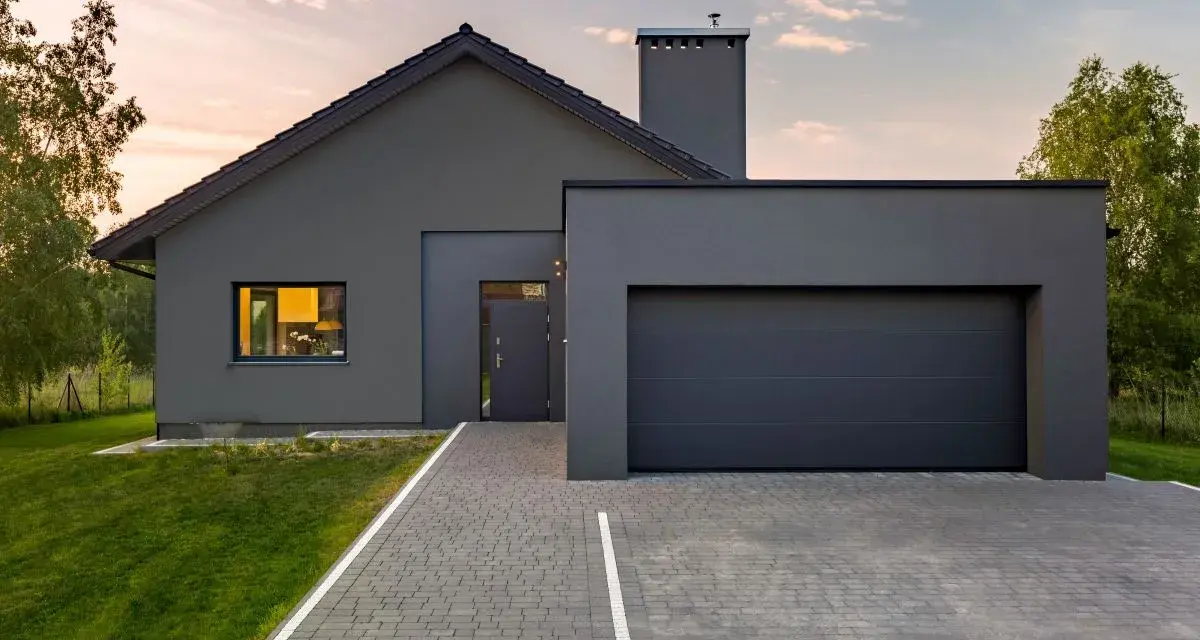 Casa moderna con tetto spiovente e garage, perfetta per un progetto di pitturare esterno casa. Il grigio antracite dona un aspetto elegante.