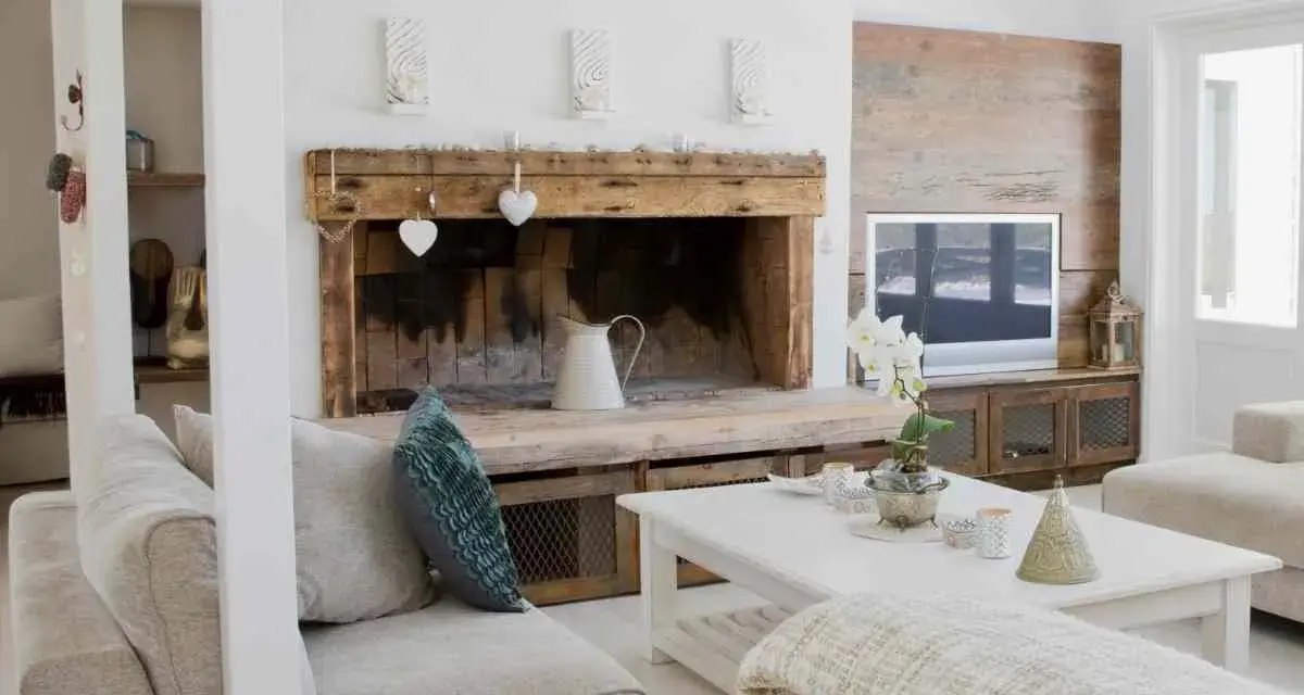 Un camino rustico con decorazioni a cuore e una brocca bianca, un'idea per come decorare un camino in stile country.