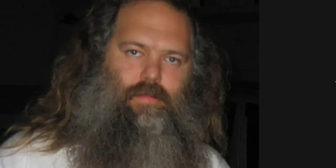 Porträt von Rick Rubin mit langem Haar und Bart, ein ikonischer Musikproduzent.