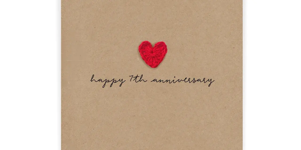 Czerwone, szydełkowe serduszko na brązowej kartce z napisem "happy 7th anniversary". Idealne na 7 rocznicę ślubu.
