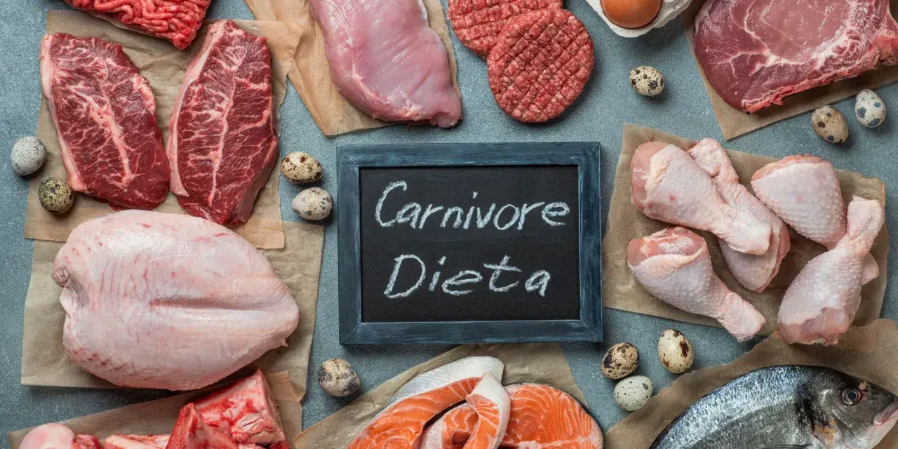 Różnorodne mięsa, ryby i jaja na stole. Tabliczka z napisem "Carnivore Dieta" sugeruje inspiracje kulinarne dla tej diety.