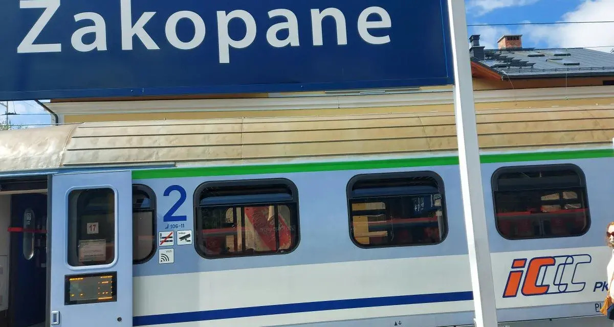 Niebieski znak "Zakopane" nad pociągiem PKP Intercity z numerem wagonu 2.
