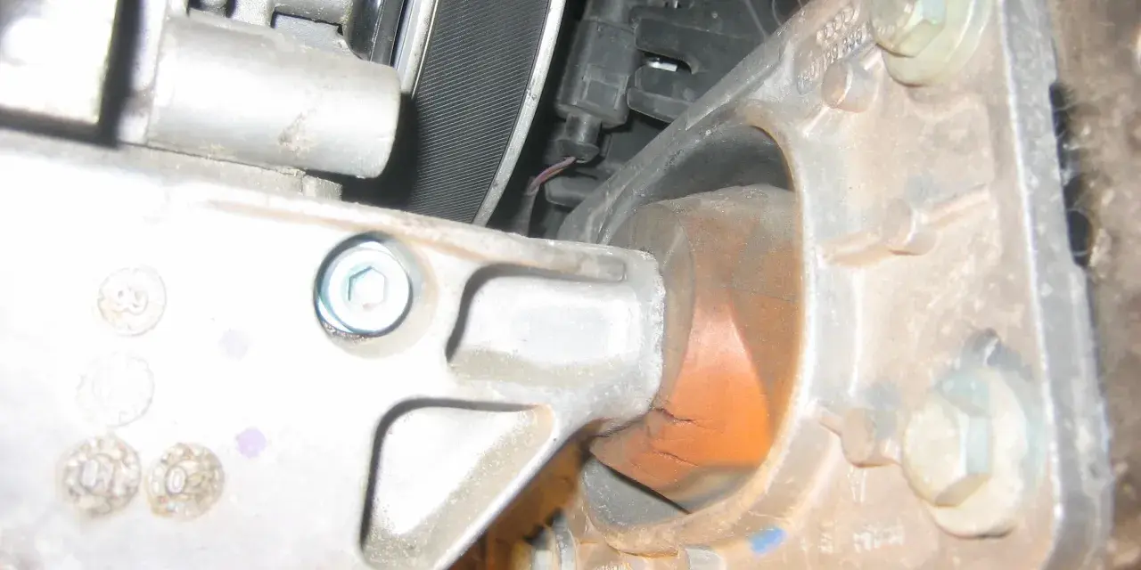 Zużyta poduszka silnika w Audi p1577. Widoczne pęknięcia gumy i metalowe elementy mocujące.