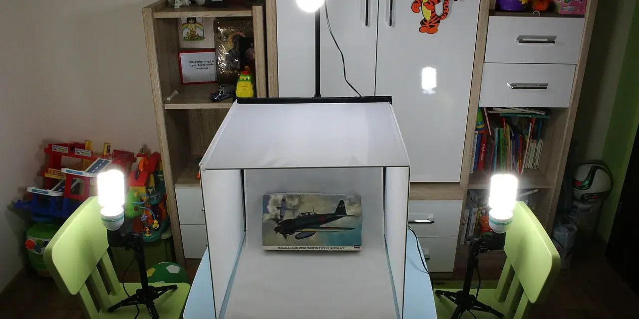Domowy namiot bezcieniowy diy oświetla model samolotu. W tle regały z zabawkami i książkami.