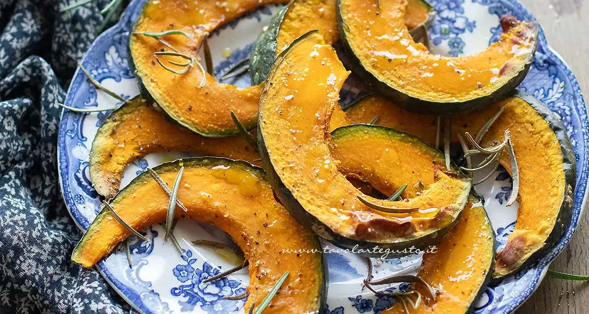 Fette di zucca in friggitrice ad aria, dorate e profumate al rosmarino, servite su un piatto blu e bianco.