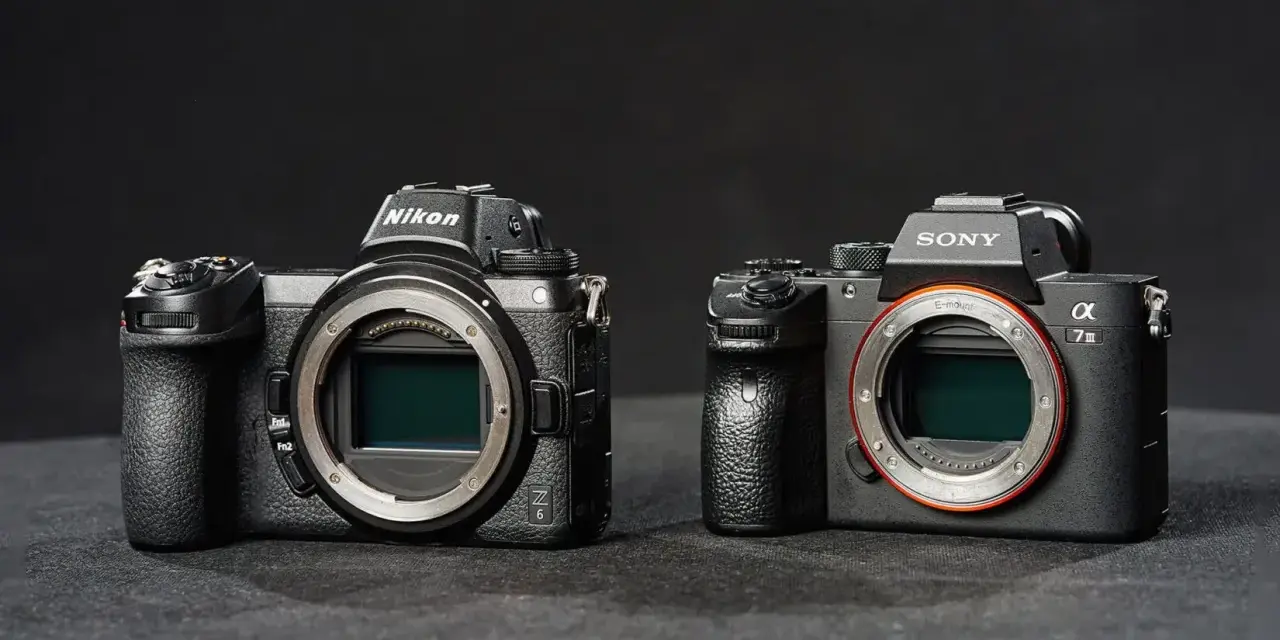 Dwie nowoczesne lustrzanki: Nikon z6 i Sony a7 III, stoją obok siebie na ciemnym tle.