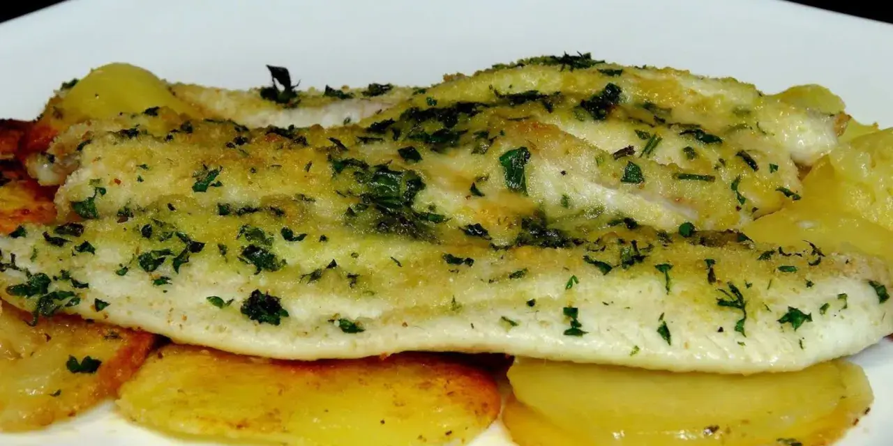 Delicioso lenguado al horno con patatas doradas y hierbas frescas.