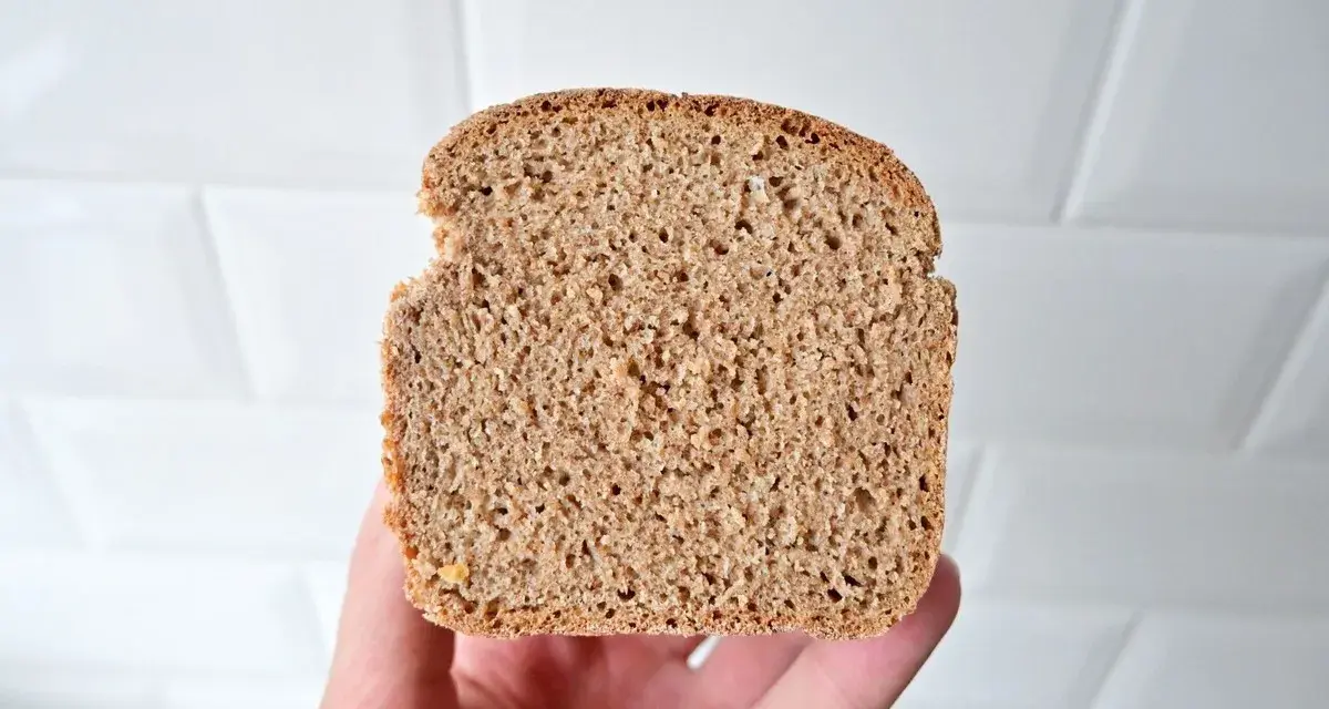 Kromka pysznego, domowego chleba graham na zakwasie, z widoczną strukturą miękiszu.