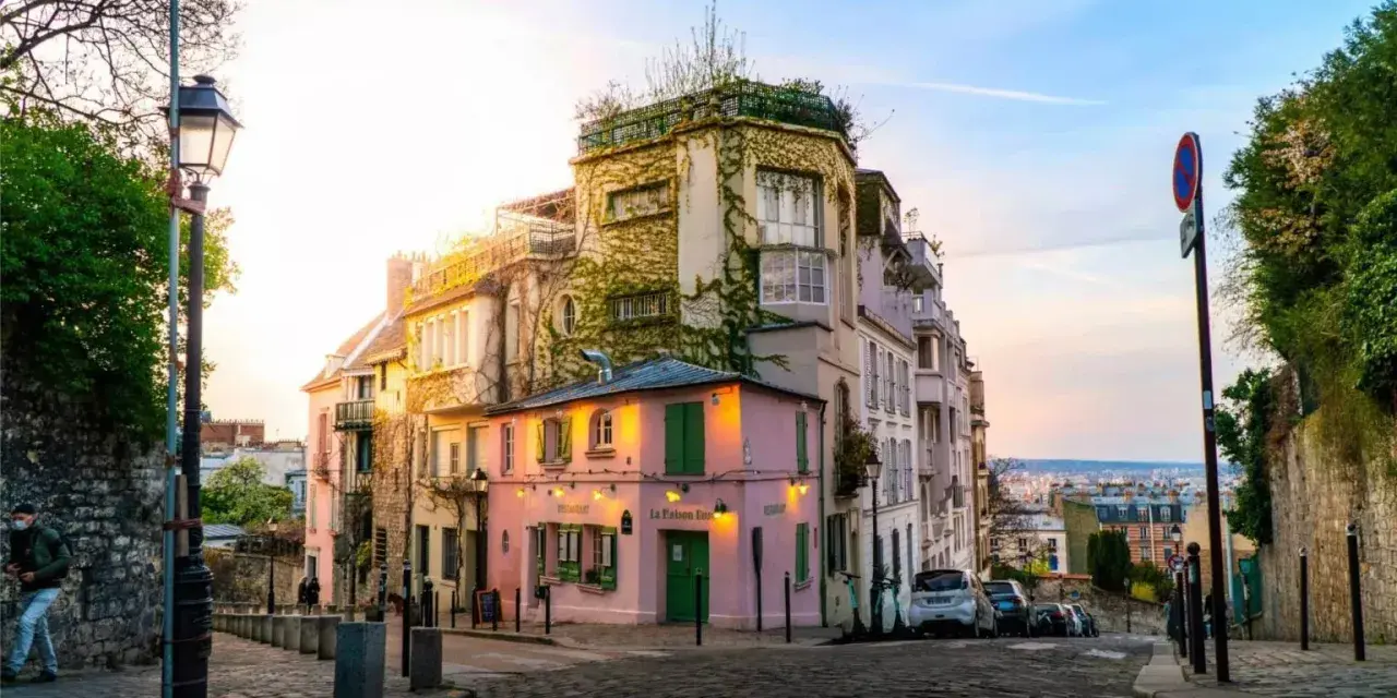 Charmante Gasse in Montmartre, Paris. Ein rosa Restaurant mit grünen Fensterläden. Tolle Paris Tipps für deinen nächsten Besuch!