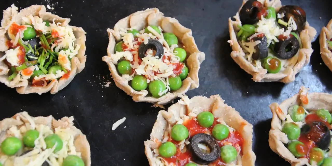 Mini pizze z groszkiem, oliwkami i serem, idealne na podwieczorek.