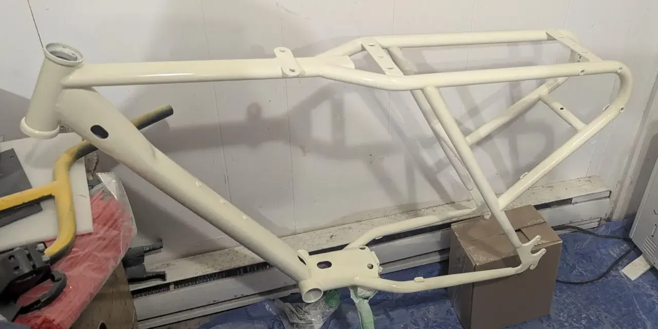 Nyligen sprayad cykelram i en ljusgul nyans, redo för nya äventyr.