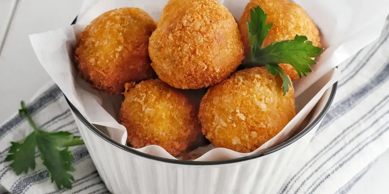 Knusprige Bitterballen, perfekt für ein leckeres Bitterballen Rezept. Serviert in einer Schüssel mit Petersilie.