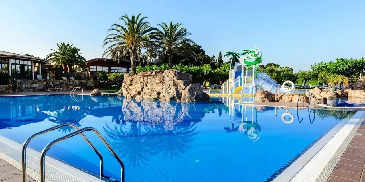 Basen w Estival Eldorado Resort z palmami i zjeżdżalniami wodnymi. Idealne miejsce na letni relaks.