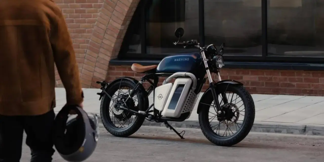Eleganckie motocykle retro w miejskiej scenerii. Mężczyzna w brązowej kurtce trzyma kask, gotowy do jazdy.