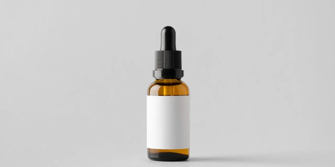 Bursztynowa buteleczka z pipetką, gotowa na zawartość, np. serum z tocopheryl acetate. Pusta biała etykieta czeka na opis.