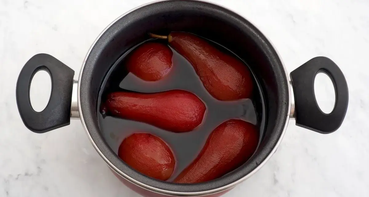 Olla con peras al vino tintas, listas para ser un postre delicioso.