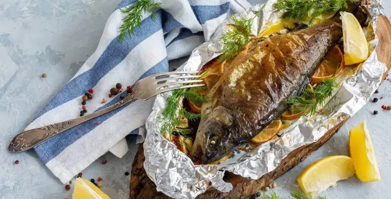 Pstrąg z grilla, pieczony w folii z cytryną i koperkiem, prezentuje się apetycznie.