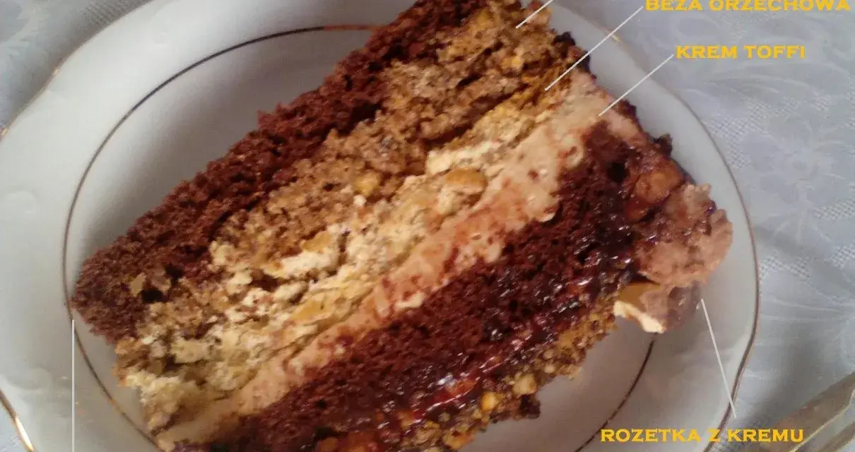Kawałek tortu toffifee z kremem toffi, bezą orzechową i czekoladą.