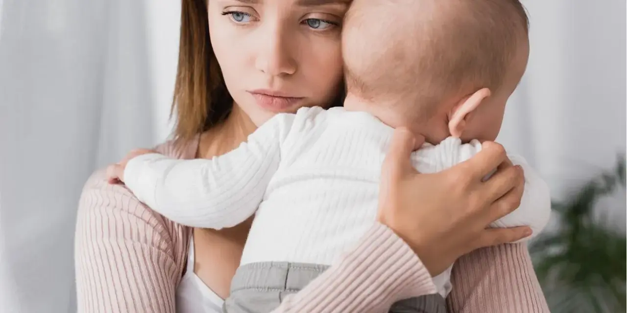 Traurige Mutter hält ihr Baby. Ihre Augen spiegeln eine tiefe Enttäuschung wider, vielleicht gender disappointment.