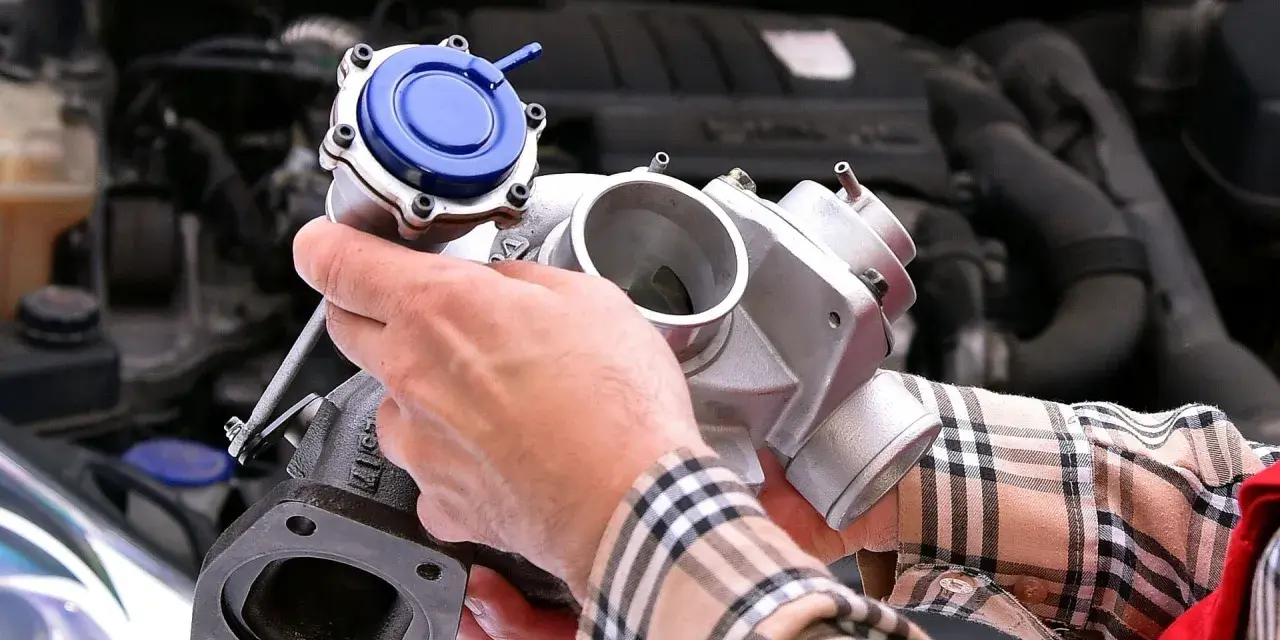 Mechanik pokazuje turbosprężarkę, element silnika, gdzie znajduje się czujnik ciśnienia doładowania.
