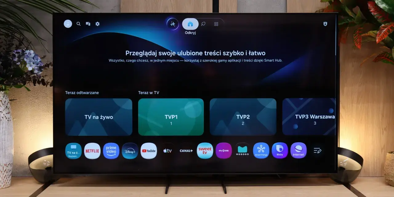 Telewizor z interfejsem Smart Hub. Widoczne aplikacje: TVP1, TVP2, Netflix, Prime Video, Disney+, YouTube.