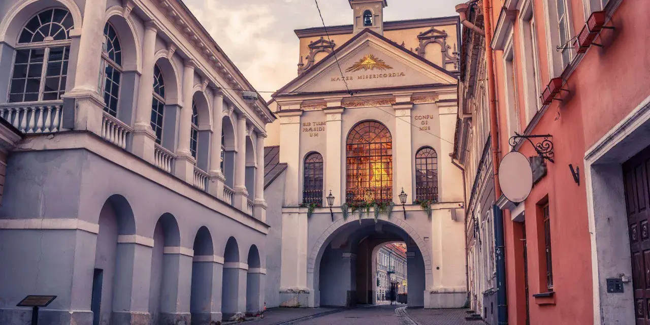 Brama w Ostrej Bramie, serce starego miasta Wilna, wita przechodniów łukiem i zabytkową architekturą.