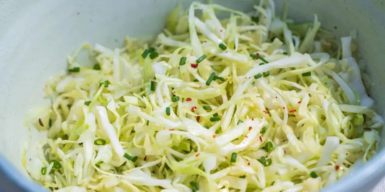Frischer Spitzkohlsalat, garniert mit Schnittlauch und Chiliflocken. Ein einfaches Rezept für jeden Tag.