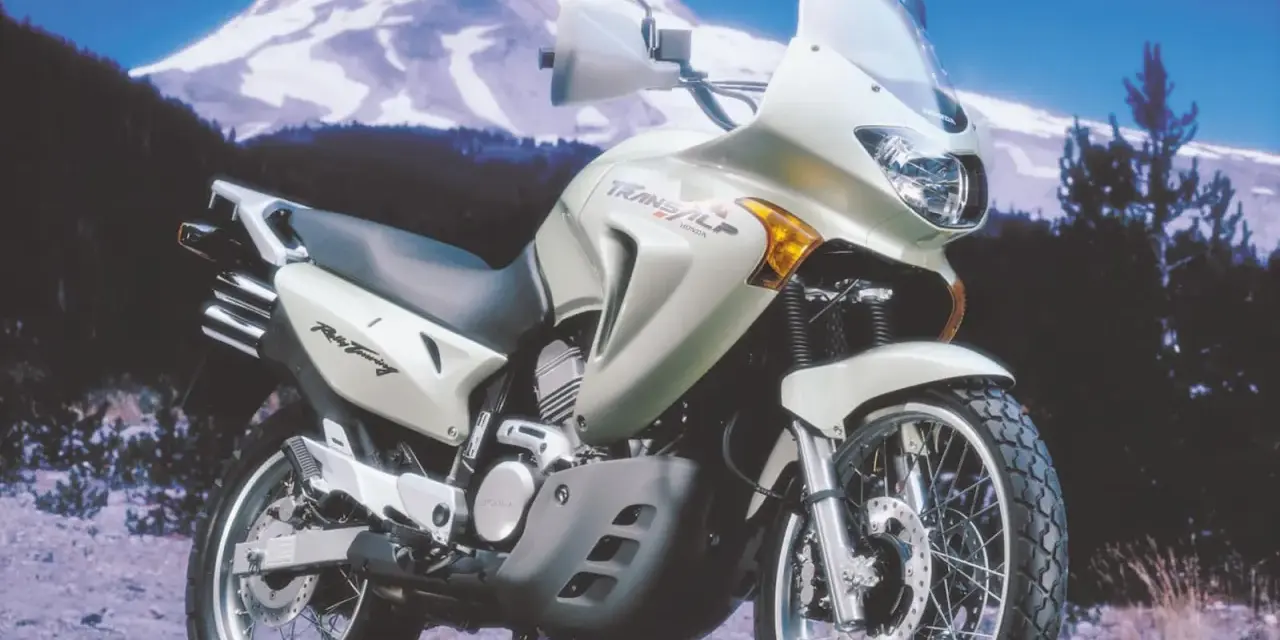 Honda Transalp 650 dane techniczne: motocykl turystyczny na tle górskiego krajobrazu. Gotowy na każdą trasę.
