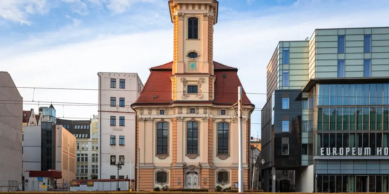 Wrocławski **dzielnica czterech świątyń** to kontrast historii i nowoczesności. Stara kamienica obok szklanego hotelu.