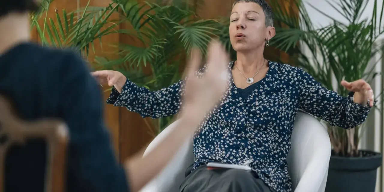 Kobieta z zamkniętymi oczami i wyrazem ulgi na twarzy, ćwicząca oddech, by poradzić sobie z dusznosciami nerwicowymi.