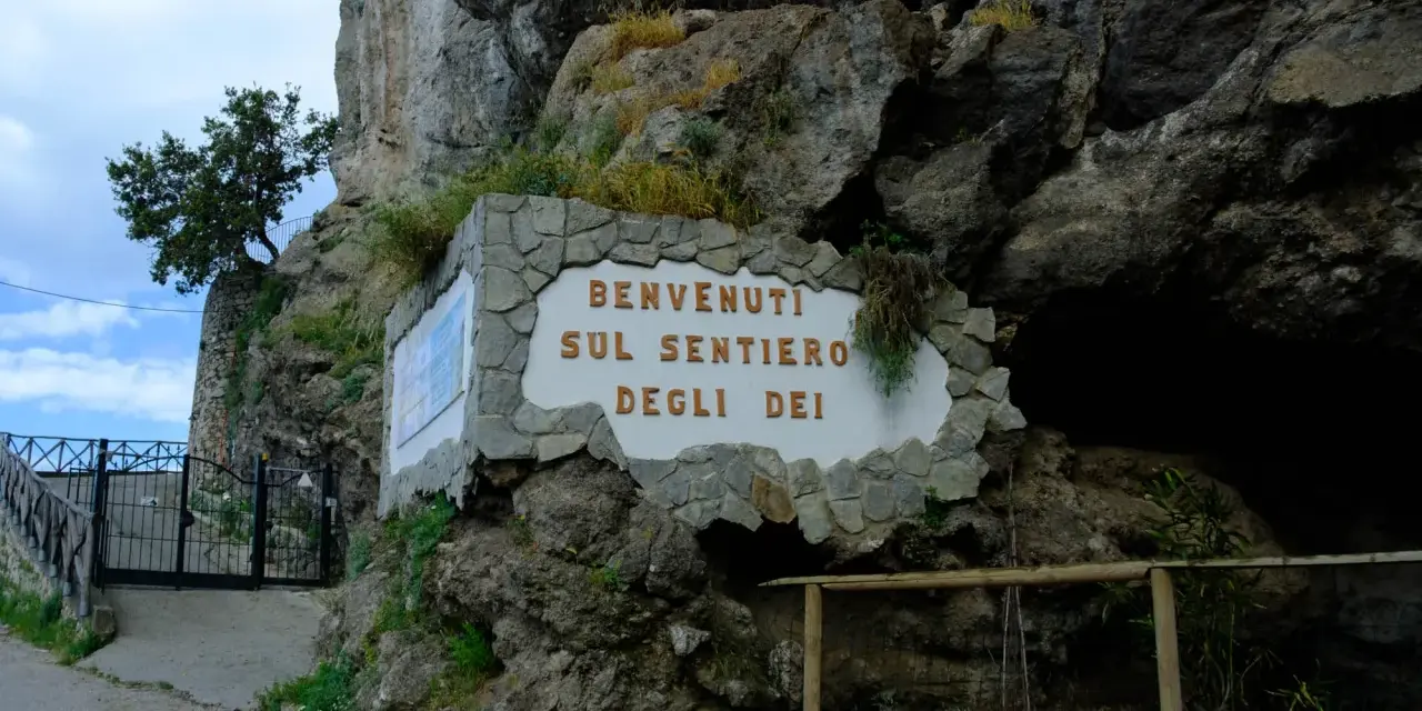 Benvenuti sul Sentiero degli Dei. Un cartello accoglie i visitatori all'inizio del percorso, incastonato nella roccia.