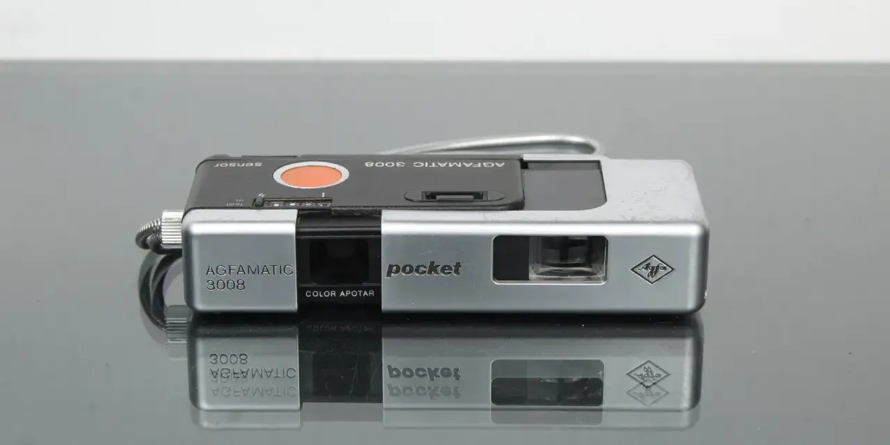 Srebrny aparat Agfamatic 3008 z napisem "pocket" i logo Agfa. Idealny do uchwycenia wspomnień.