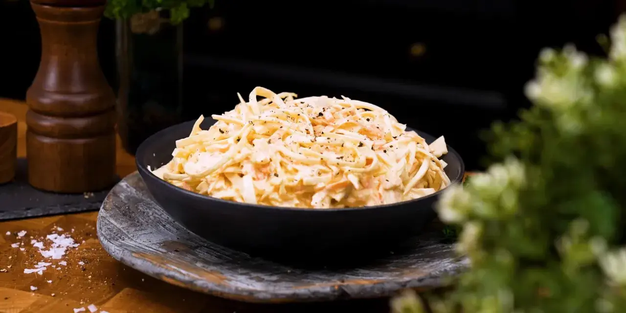 En skål med krämig, godaste coleslaw, toppad med peppar. Perfekt tillbehör!