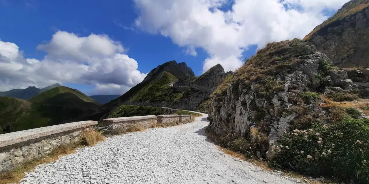 Strade panoramiche Liguria in moto: un percorso tortuoso tra montagne verdi e cielo azzurro, ideale per un'avventura su due ruote.