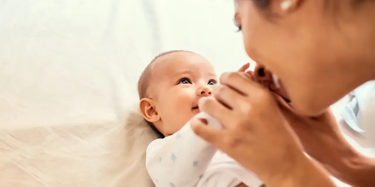Mama czule głaszcze niemowlę, które wpatruje się w nią z zaciekawieniem. Choć ma dopiero kilka miesięcy, już widać, że to **3 letnie dziecko nie reaguje na imię**, co martwi rodziców.
