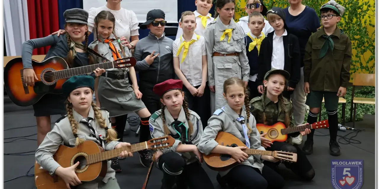 Dzieci w strojach harcerskich grają na gitarach i mandolinie. To może być zapowiedź piosenki o harnasiu.