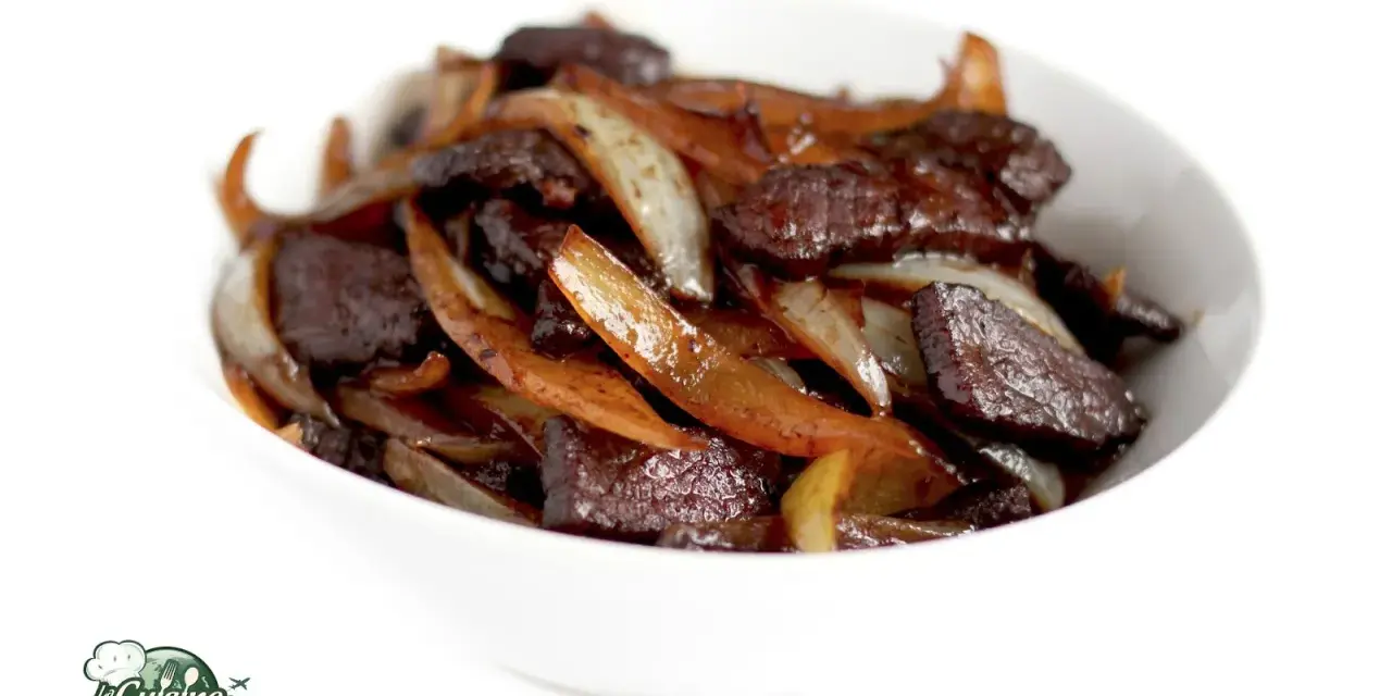 Un délicieux sauté de bœuf aux oignons caramélisés, servi dans un bol blanc. Un plat savoureux et réconfortant.