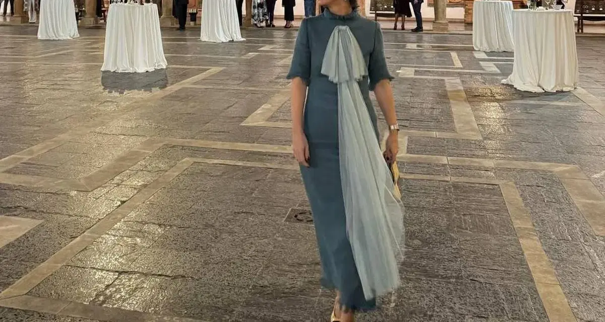 Elegante mujer con vestido azul claro y velo, lista para los Premios Princesa de Asturias.