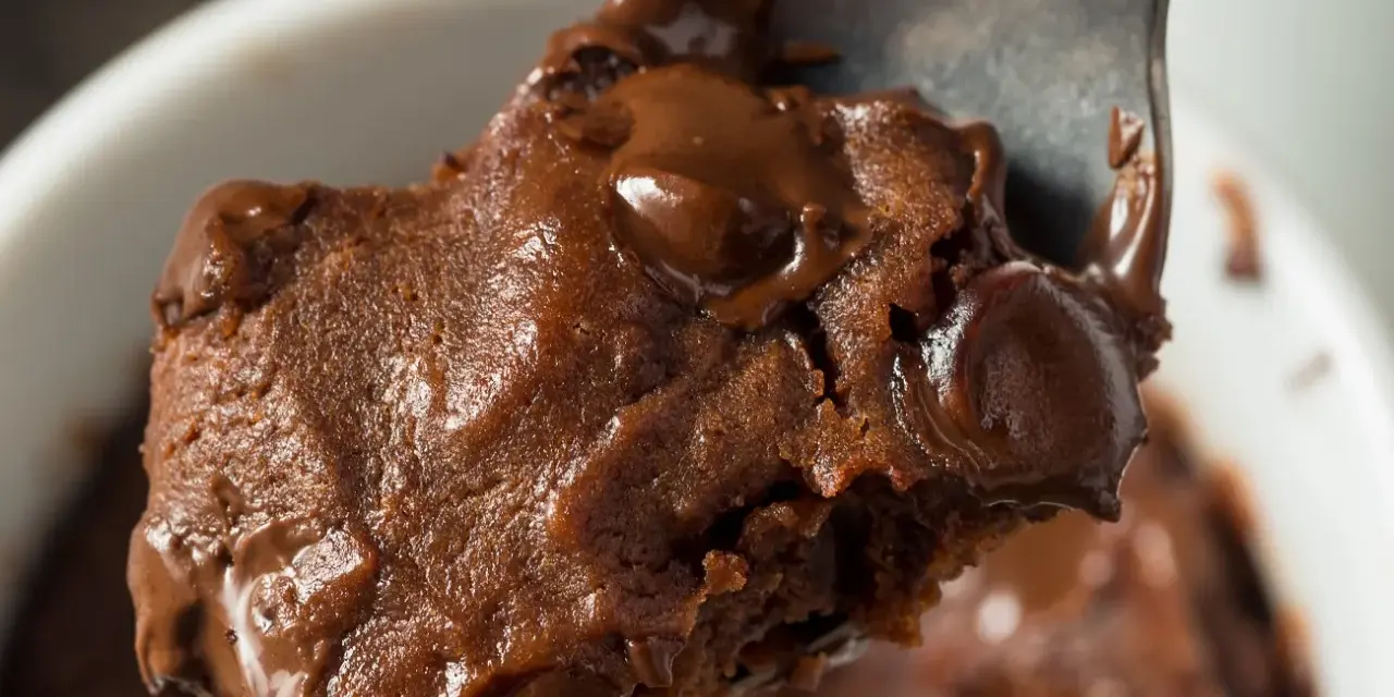 Łyżka z porcją pysznej, pieczonej owsianki brownie z roztopioną czekoladą.