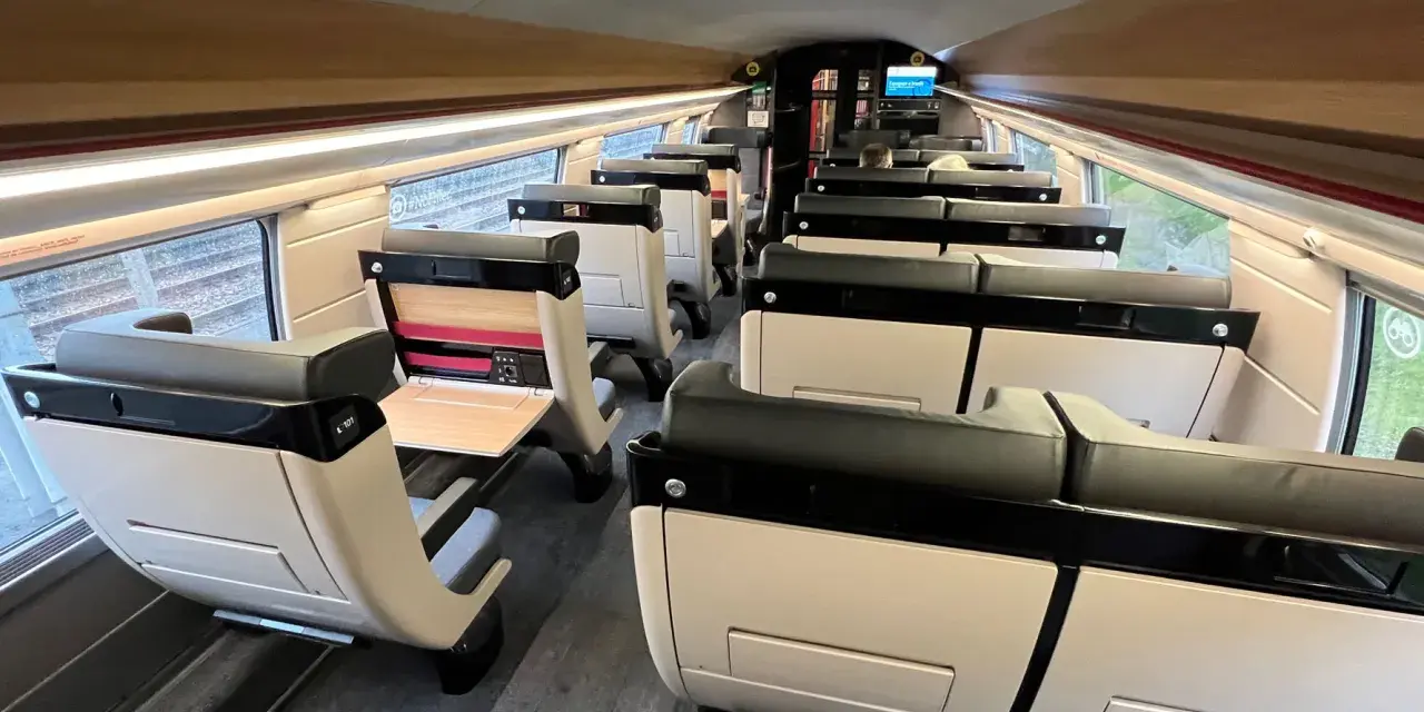 Interior of a modern train carriage, likely the Paris to Bilbao train, with rows of comfortable, beige and black seats.