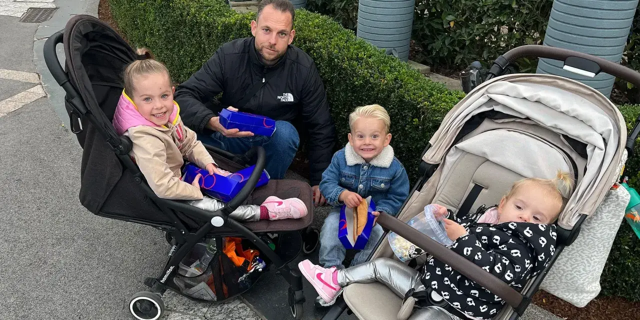 Familie genießt Snacks, um Disneyland Paris Essen mitzunehmen. Kinder in Kinderwagen und Vater mit Boxen.