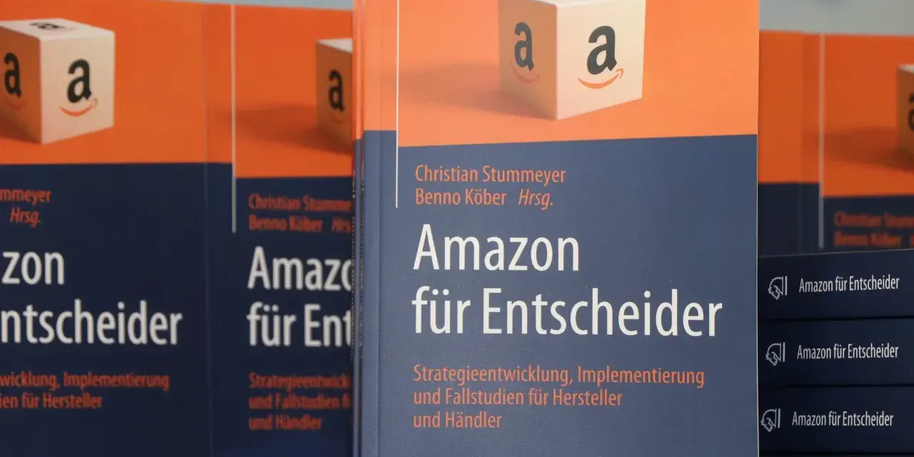 Bücher "Amazon für Entscheider" mit Amazon-Logo-Würfel im Vordergrund.
